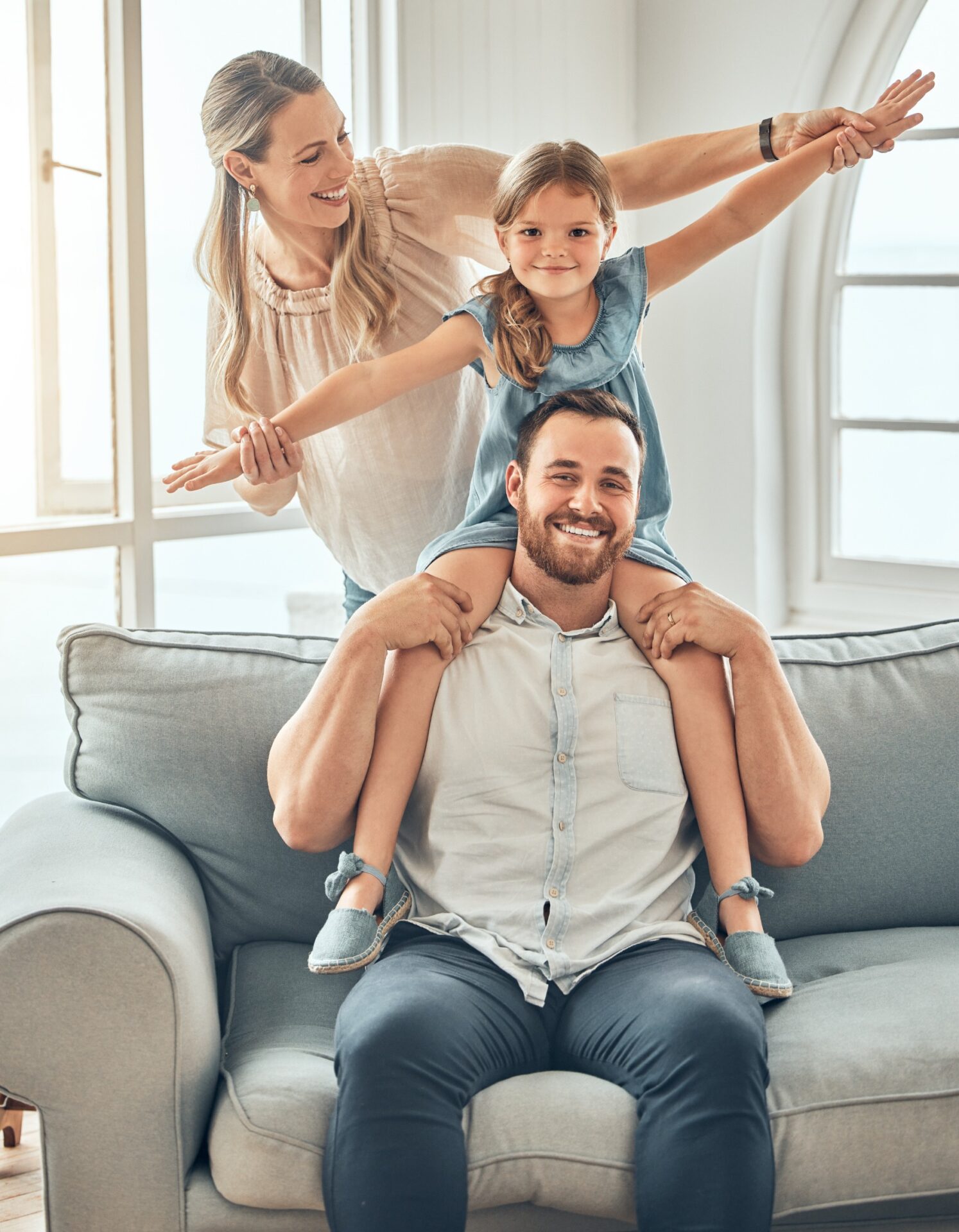 Mother, father and kid playing on couch